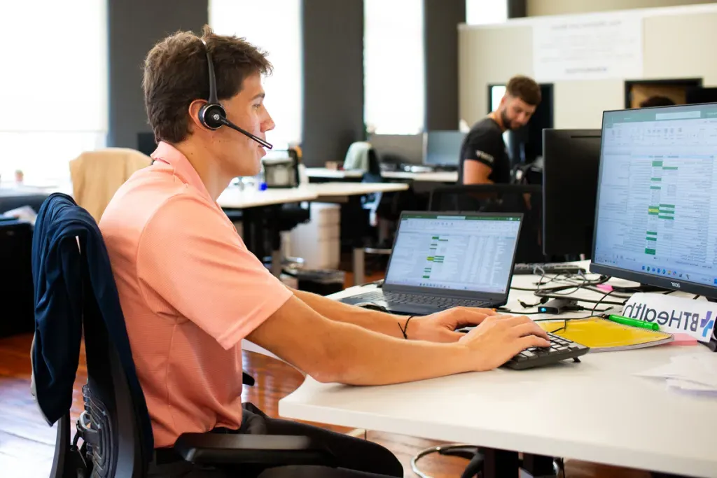 A Business Administration student sits in an office setting for his sales internship