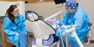 UNE dental students engage with a child patient in the Oral Health Center